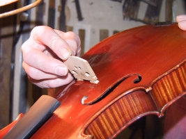 Ajustage d'un chevalet de violon.