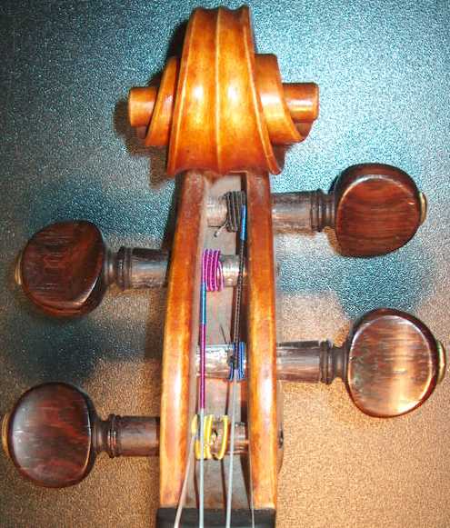 rolling up of strings in pegs in peg box of a violin.